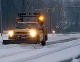 snowplow on road in winter storm